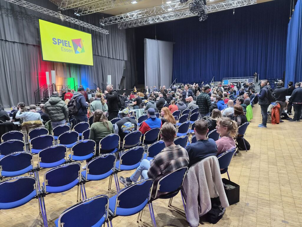 Bestuhlter Saal mit Menschen.