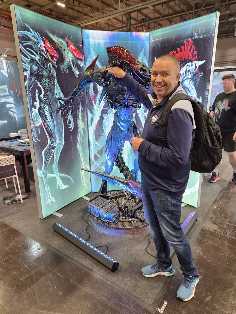 Mann hält Alien Hand ins Maul.
