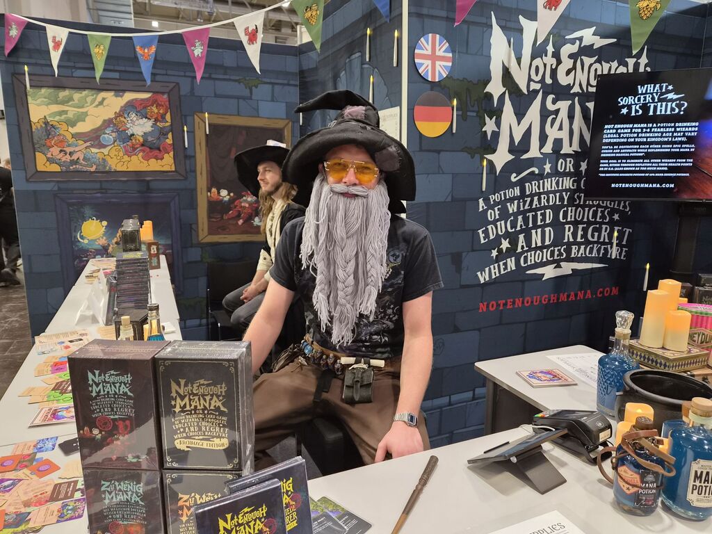 Mann mit falschem Bart aus Wolle an Messestand.