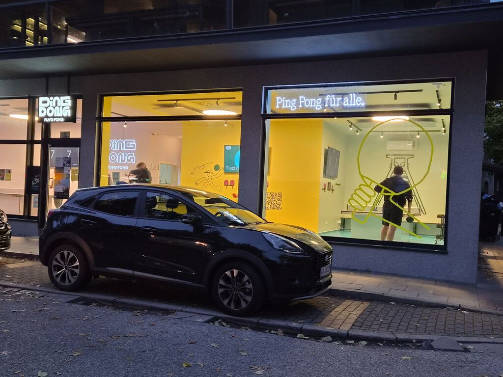 Schaufenster, dahinter Menschen beim Tischtennis.