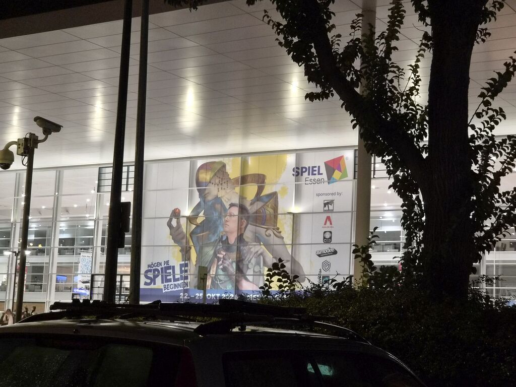 Beleuchteter Messeeingang bei Nacht.
