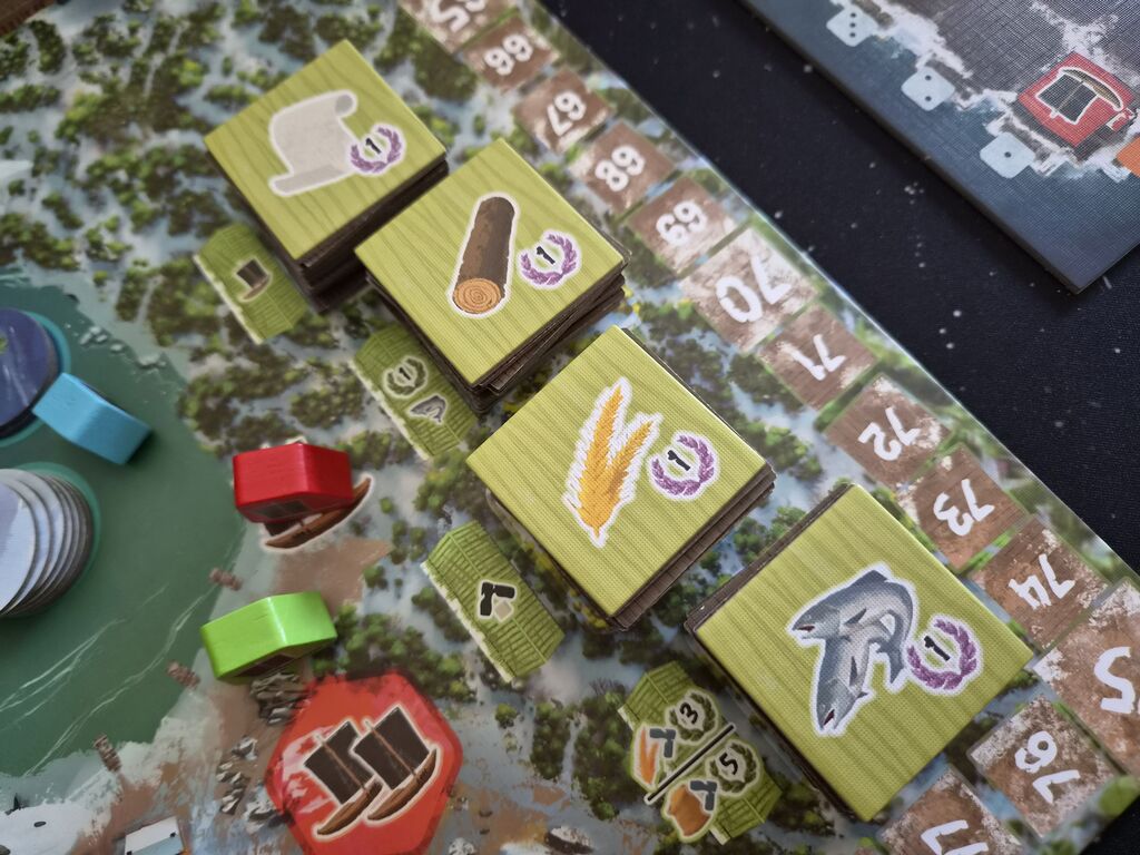 Plättchen mit Symbolen auf Spielplan.