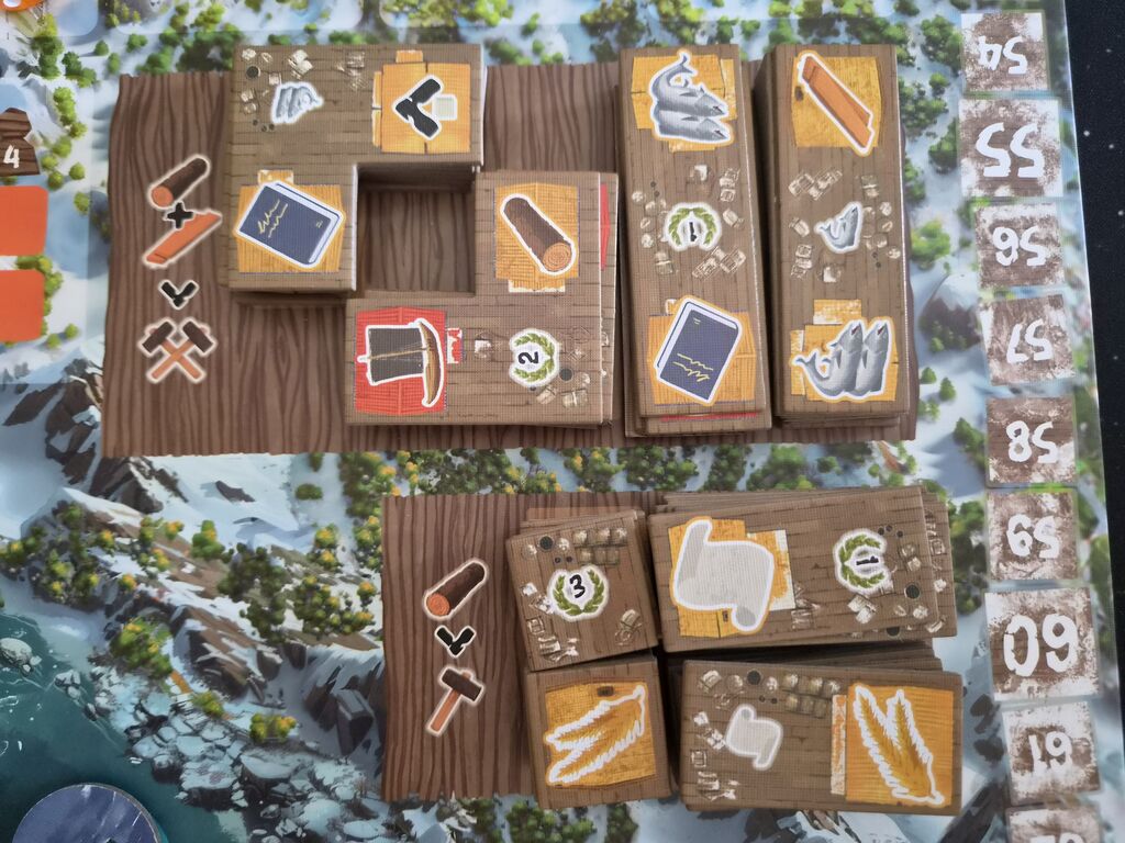 Plättchen auf Spielplan mit Symbolen.