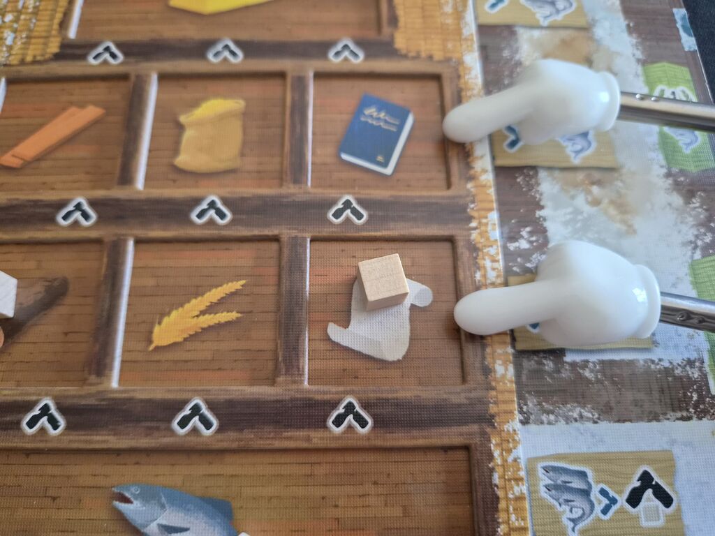 Zeiger zeigen auf zwei Felder auf Lagertableau. Im unteren liegt ein Holzwürfel.